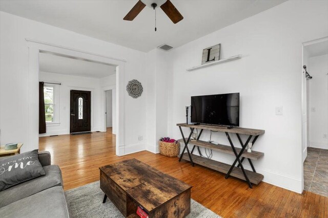 living room with visible vents, baseboards, ceiling fan, and wood finished floors