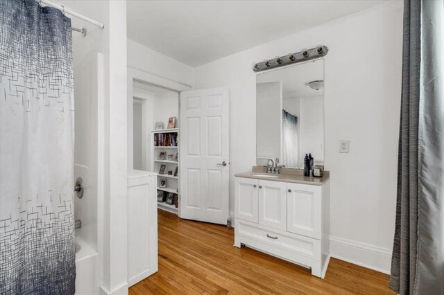 full bathroom with vanity, shower / tub combo with curtain, and wood finished floors
