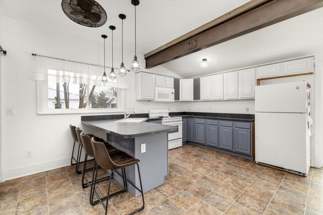 kitchen with gray cabinets, stone finish flooring, dark countertops, a sink, and white appliances