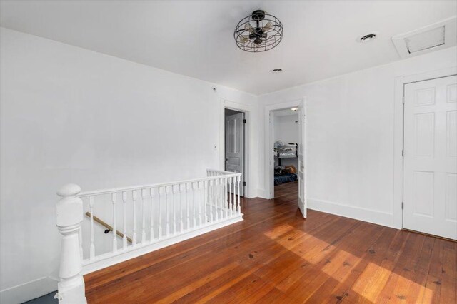 interior space featuring wood-type flooring, attic access, baseboards, and visible vents