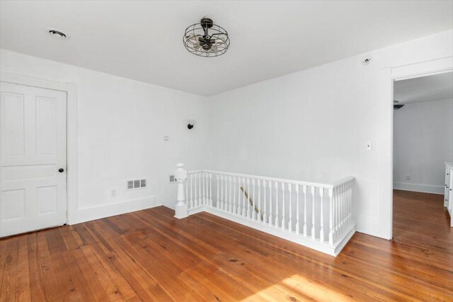 spare room with baseboards, hardwood / wood-style flooring, and visible vents