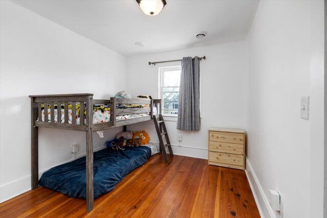 bedroom featuring wood-type flooring and baseboards