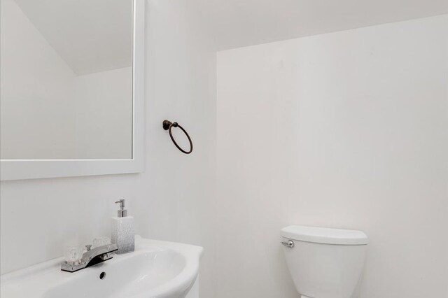half bathroom featuring a sink and toilet