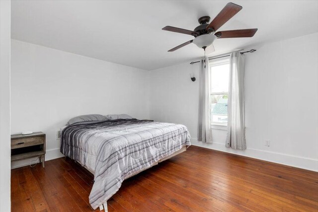 bedroom with a ceiling fan, baseboards, and hardwood / wood-style flooring