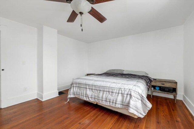 bedroom featuring baseboards, ceiling fan, and wood finished floors