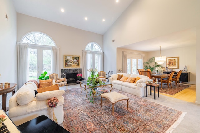 living room featuring high vaulted ceiling, a wealth of natural light, a fireplace, and visible vents