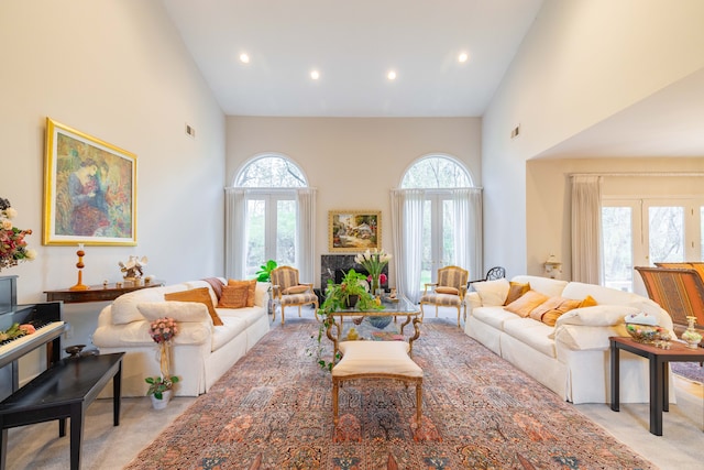 living area with light colored carpet, recessed lighting, a healthy amount of sunlight, and high vaulted ceiling