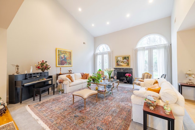 living room featuring recessed lighting, high vaulted ceiling, wood finished floors, and a high end fireplace