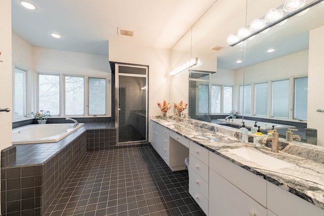 full bath featuring a sink, tile patterned flooring, double vanity, a shower stall, and a garden tub