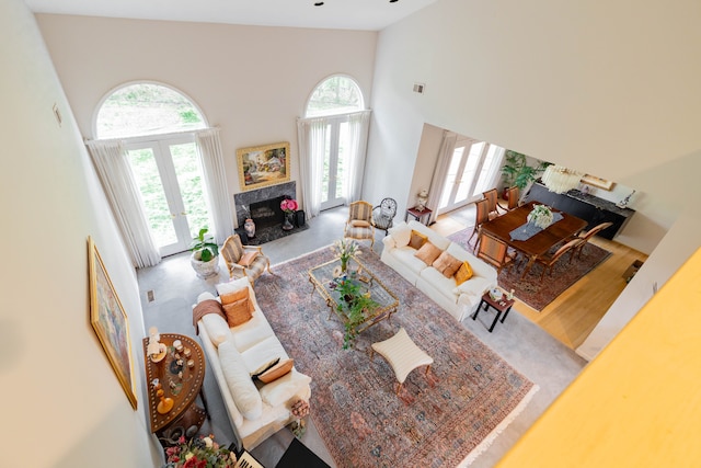 living area with high vaulted ceiling, french doors, and a premium fireplace