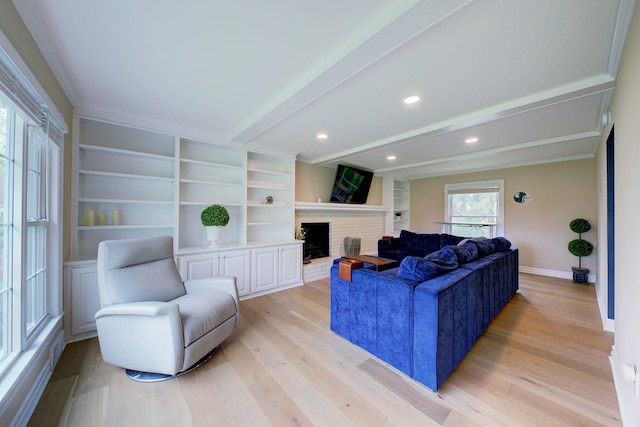 living room featuring light wood-style flooring, a brick fireplace, beamed ceiling, and baseboards