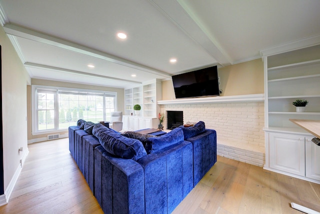 living area featuring beamed ceiling, light wood finished floors, a fireplace, and visible vents