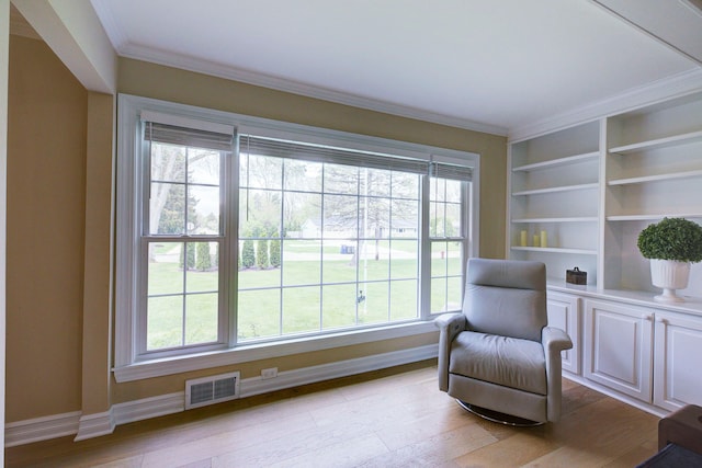 living area with crown molding, light wood-type flooring, visible vents, and baseboards