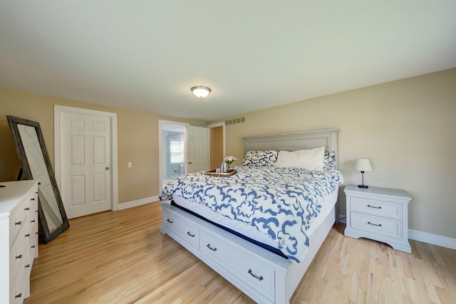 bedroom featuring light wood finished floors, baseboards, and visible vents