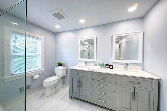 bathroom with toilet, visible vents, a sink, and a shower stall