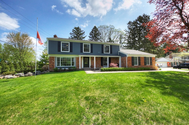traditional home featuring a chimney, a front yard, brick siding, and covered porch
