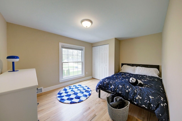 bedroom featuring baseboards, a closet, visible vents, and wood finished floors