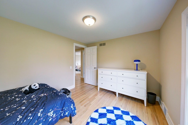 bedroom featuring visible vents, light wood-style flooring, and baseboards