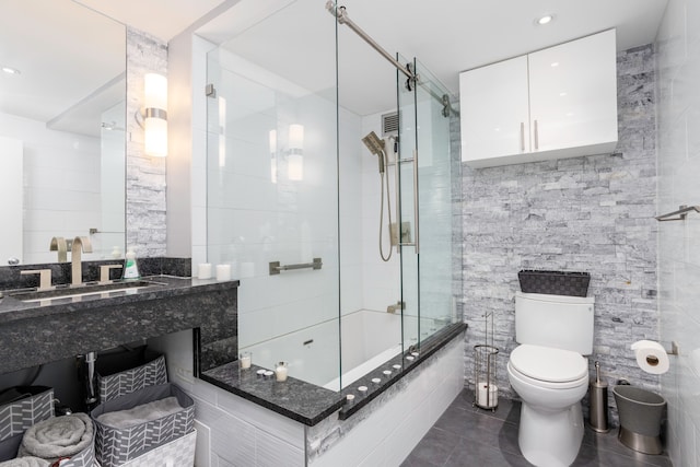 full bath with toilet, tile walls, tiled shower / bath, recessed lighting, and tile patterned floors