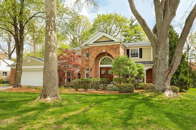traditional home featuring brick siding, a garage, and a front yard