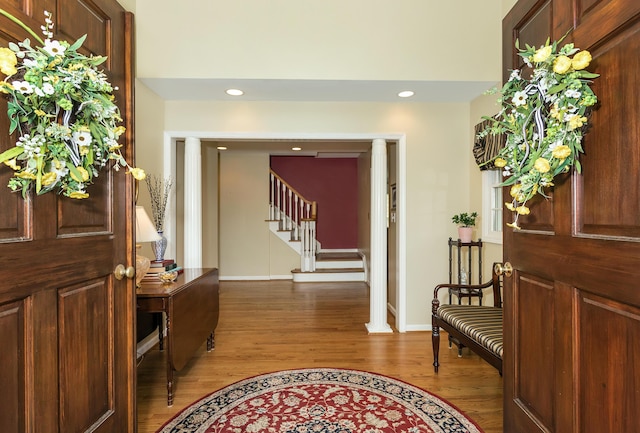 foyer with baseboards, recessed lighting, stairs, and wood finished floors