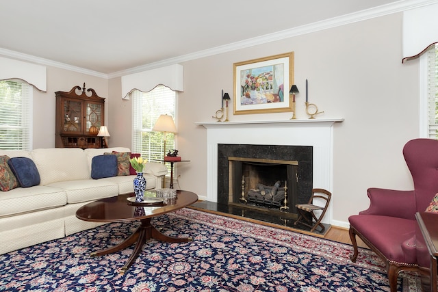 living room featuring a fireplace with raised hearth, ornamental molding, wood finished floors, and a wealth of natural light