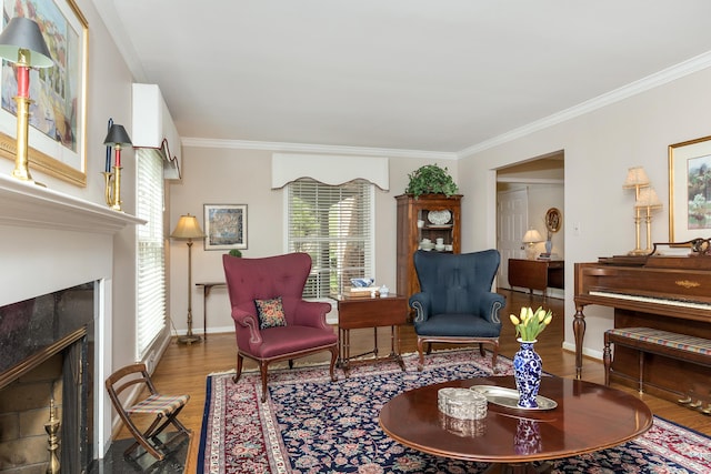 sitting room featuring crown molding, baseboards, wood finished floors, and a fireplace