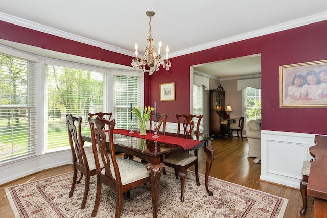 dining space with ornamental molding, wood finished floors, and a chandelier