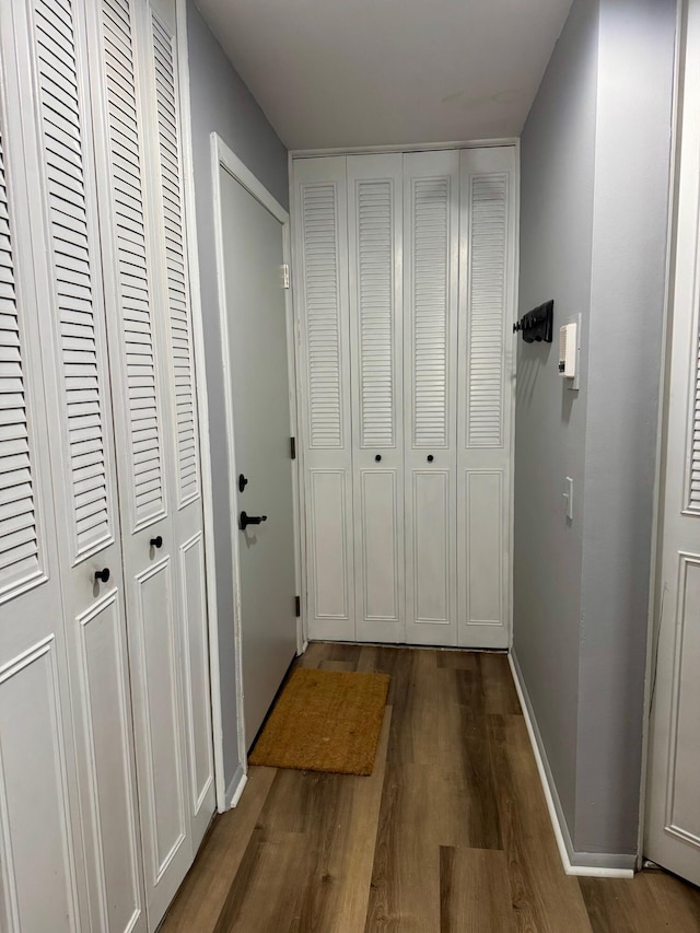 hall with baseboards and dark wood finished floors