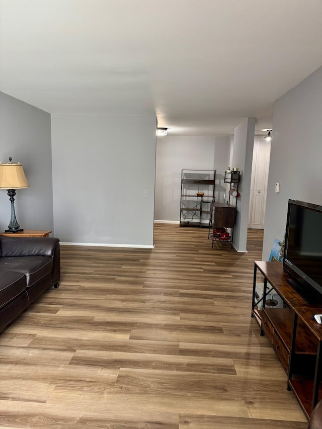 living area featuring baseboards and light wood-style flooring