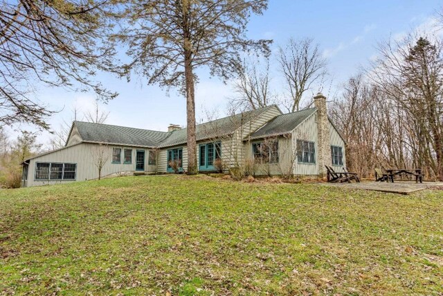 ranch-style home featuring a front lawn and a chimney