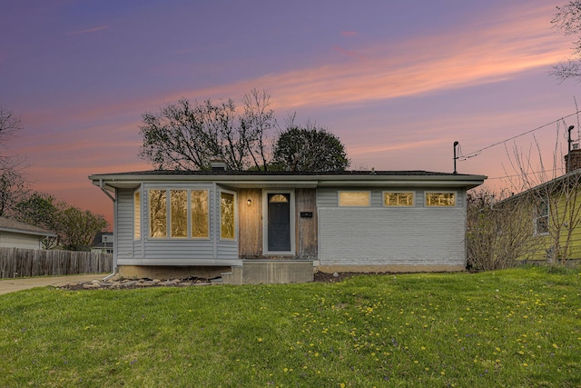 view of front facade with a front lawn and fence