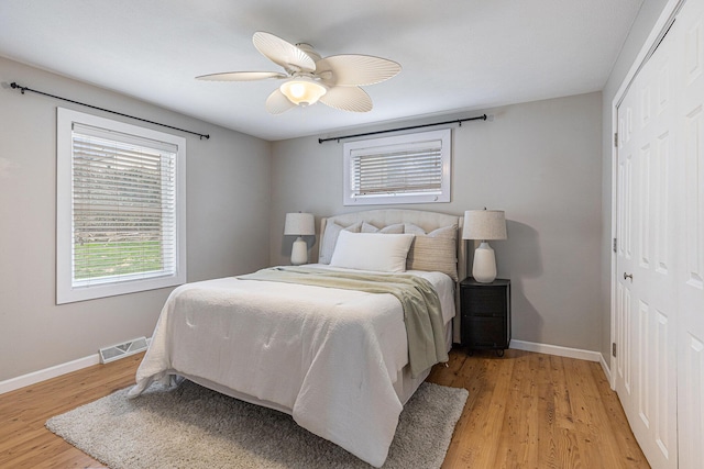 bedroom featuring visible vents, baseboards, light wood-style floors, and a closet
