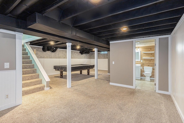 finished basement with wooden walls, carpet floors, stairs, and pool table