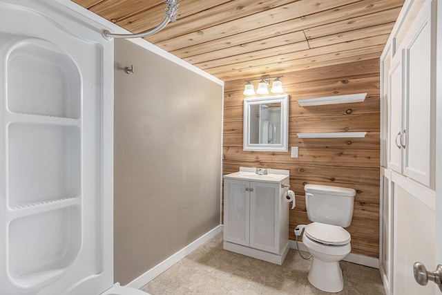 bathroom featuring vanity, toilet, baseboards, wooden walls, and wood ceiling