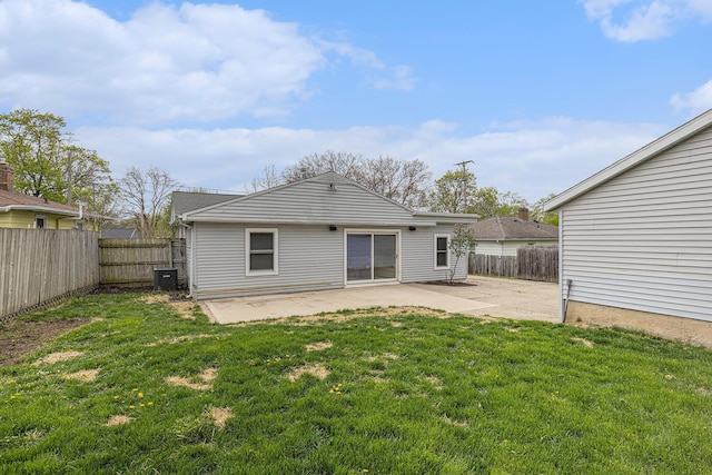 back of house with a fenced backyard, a patio, and a lawn
