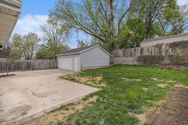 view of yard with a fenced backyard, an outbuilding, and a detached garage