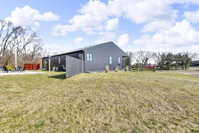 view of property exterior featuring an outbuilding, a yard, and central AC unit
