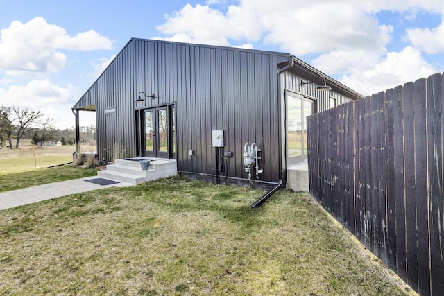 view of outdoor structure featuring fence and french doors
