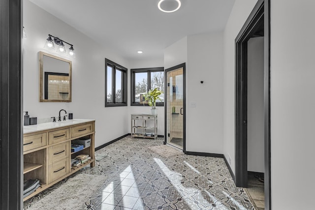 full bath featuring baseboards, vanity, and a stall shower