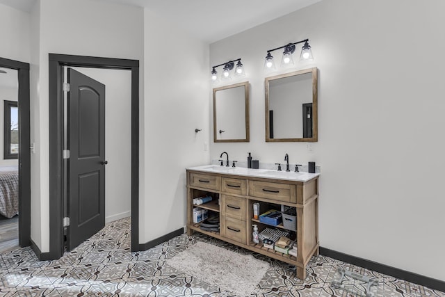 full bathroom with a sink, baseboards, tile patterned flooring, and double vanity