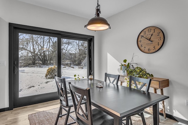 dining area with baseboards and light wood-style flooring