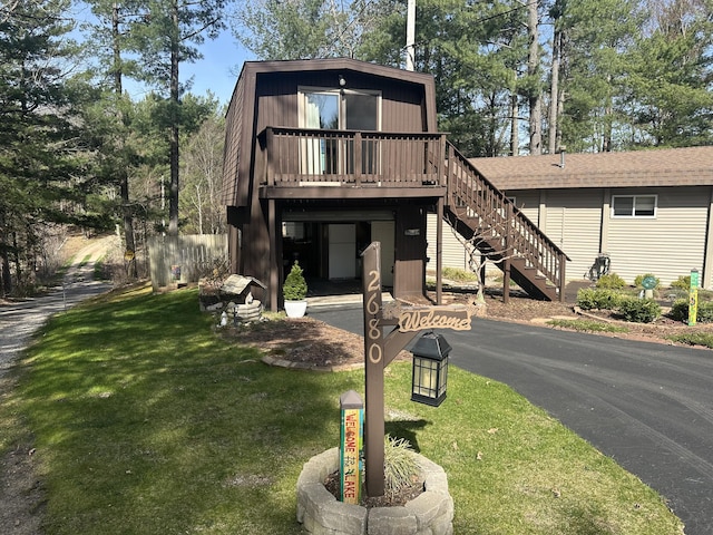 a-frame style home featuring a wooden deck, stairs, and a front yard