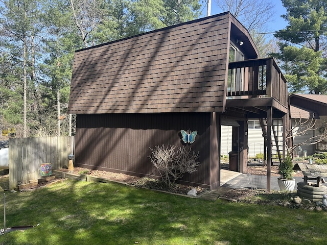 view of side of home featuring an outbuilding, a wooden deck, and a yard