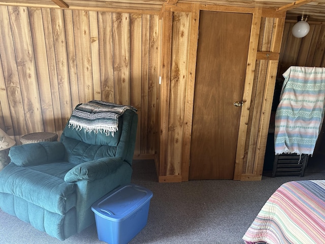 carpeted bedroom featuring wooden walls