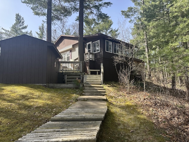 rear view of property with stairway and a deck