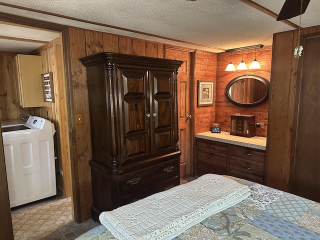 bedroom with wooden walls, a textured ceiling, and washing machine and clothes dryer