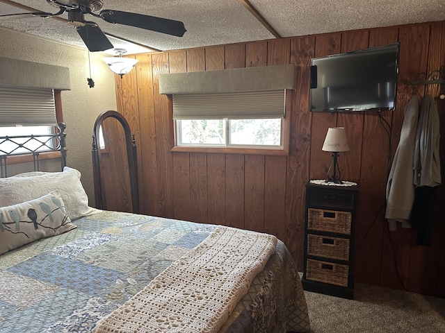 carpeted bedroom with a ceiling fan and wood walls