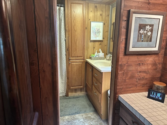 bathroom with vanity and wood walls