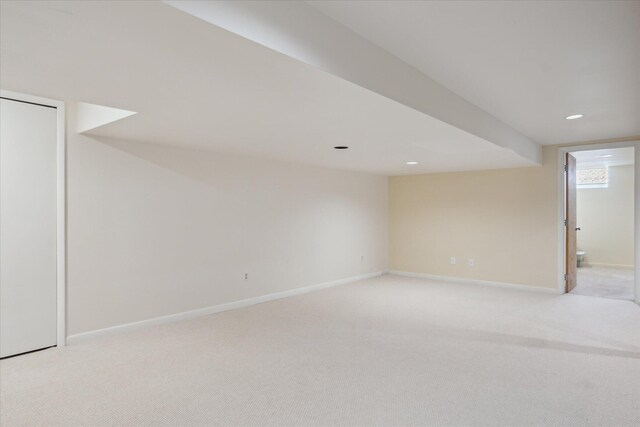 basement featuring recessed lighting, baseboards, and light colored carpet